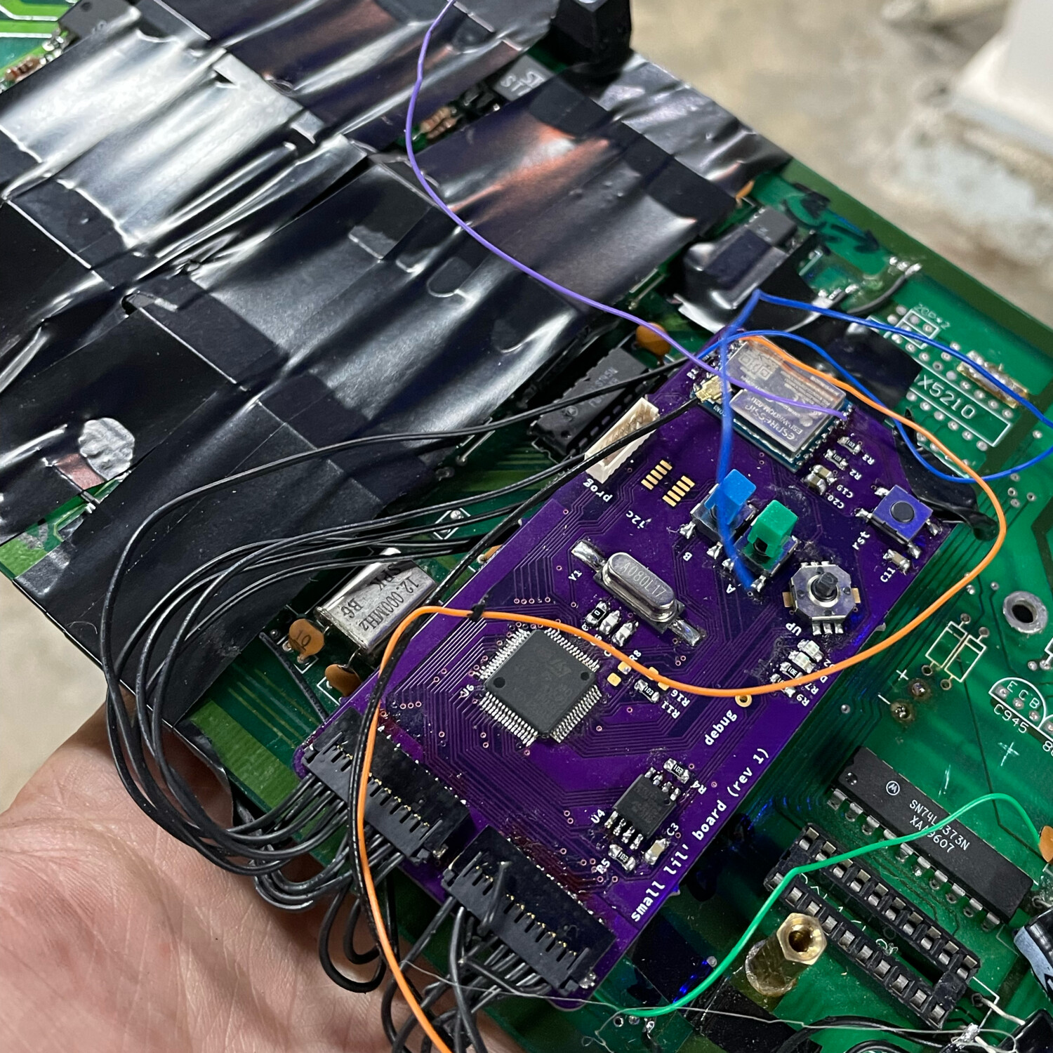 My "small lil board" fit nicely onto a socket on the main board. Clerances were tight, so a few wraps of electrical tape and some cardboard did the trick to insulate the board.